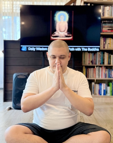 Man seated in meditation posture showing respect before a Buddhist Teaching.